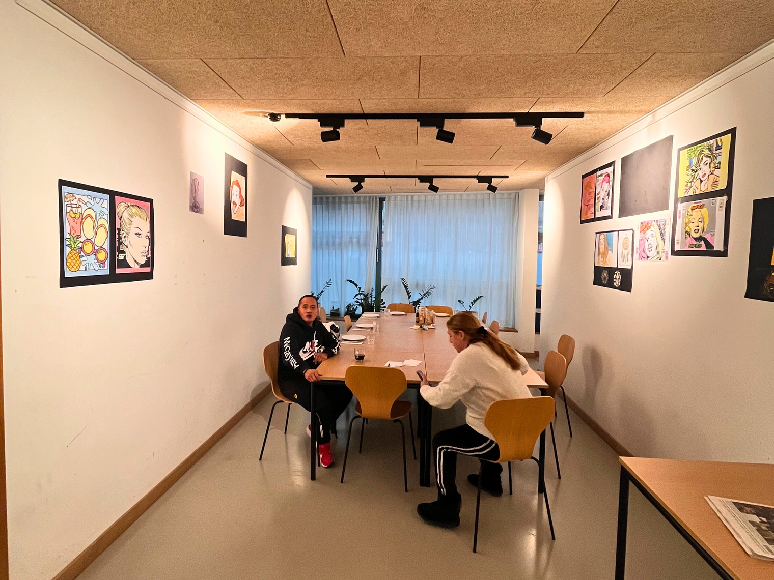 Une salle d'activités avec deux personnes assises à une table