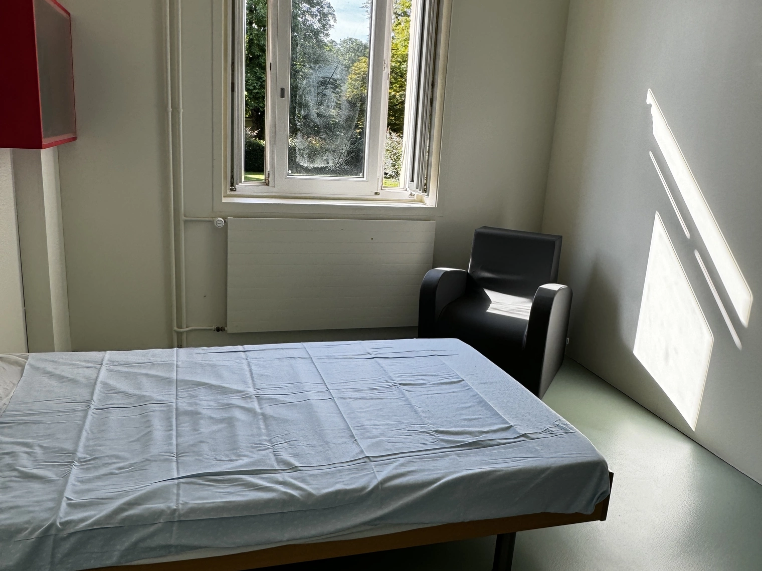 Une chambre avec une fenêtre avec vue sur le parc et un lit