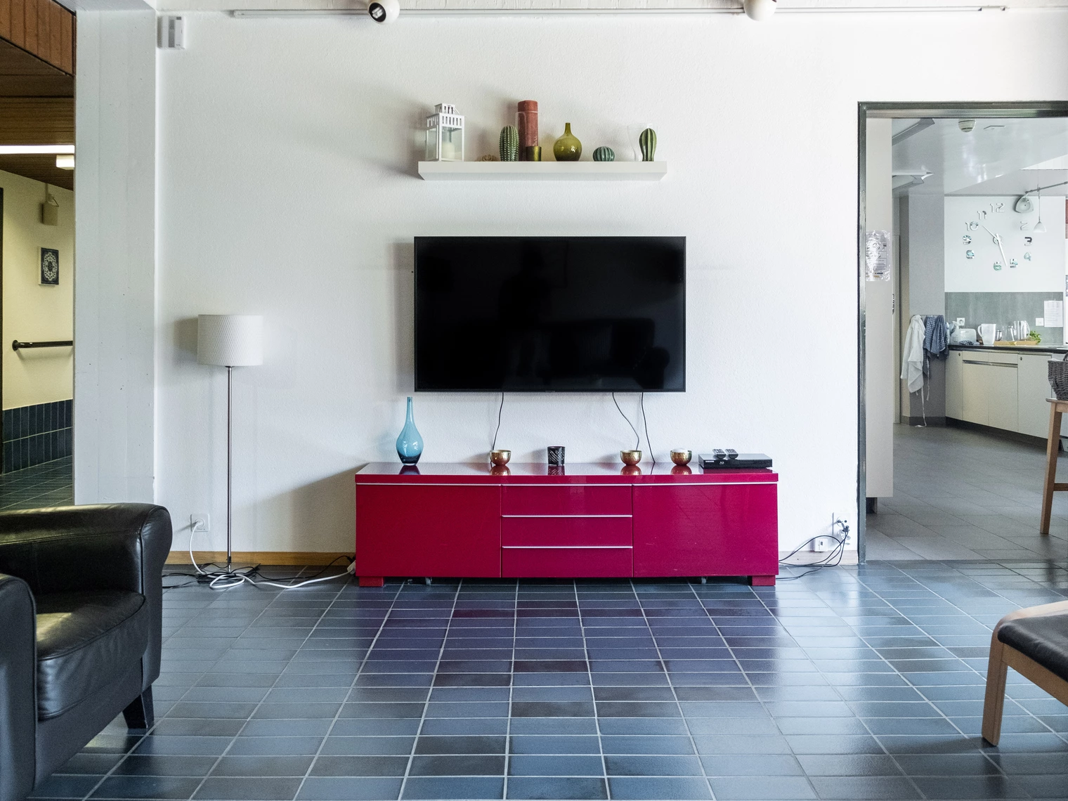 Un salon avec une grande télévision au mur et un meuble télé