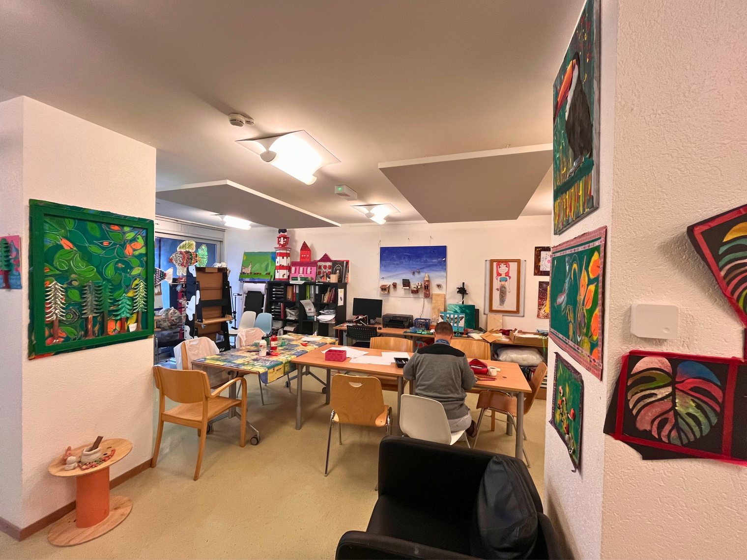 Une salle d'activités avec des dessins et peintures au mur
