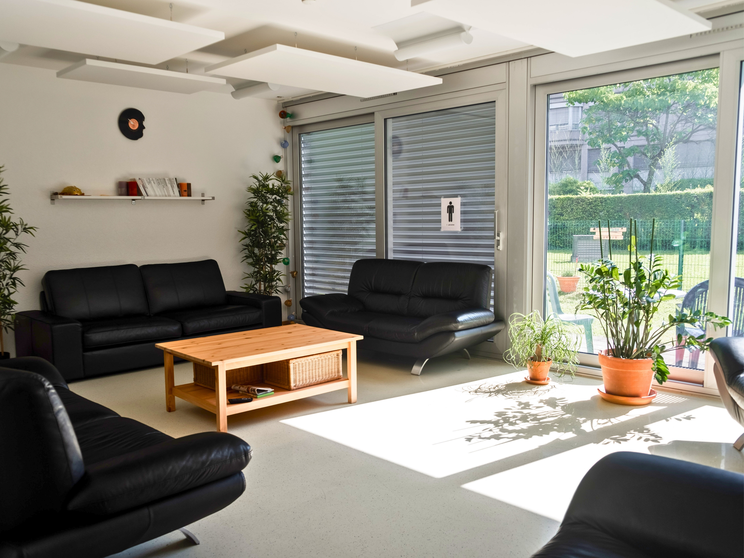 Une salle de détente avec des canapés, une table basse et une grande baie vitrée 