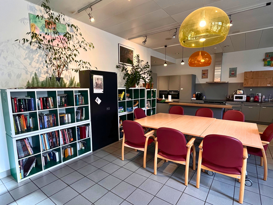 Une salle d'activités avec une bibliothèque, une table et des chaises