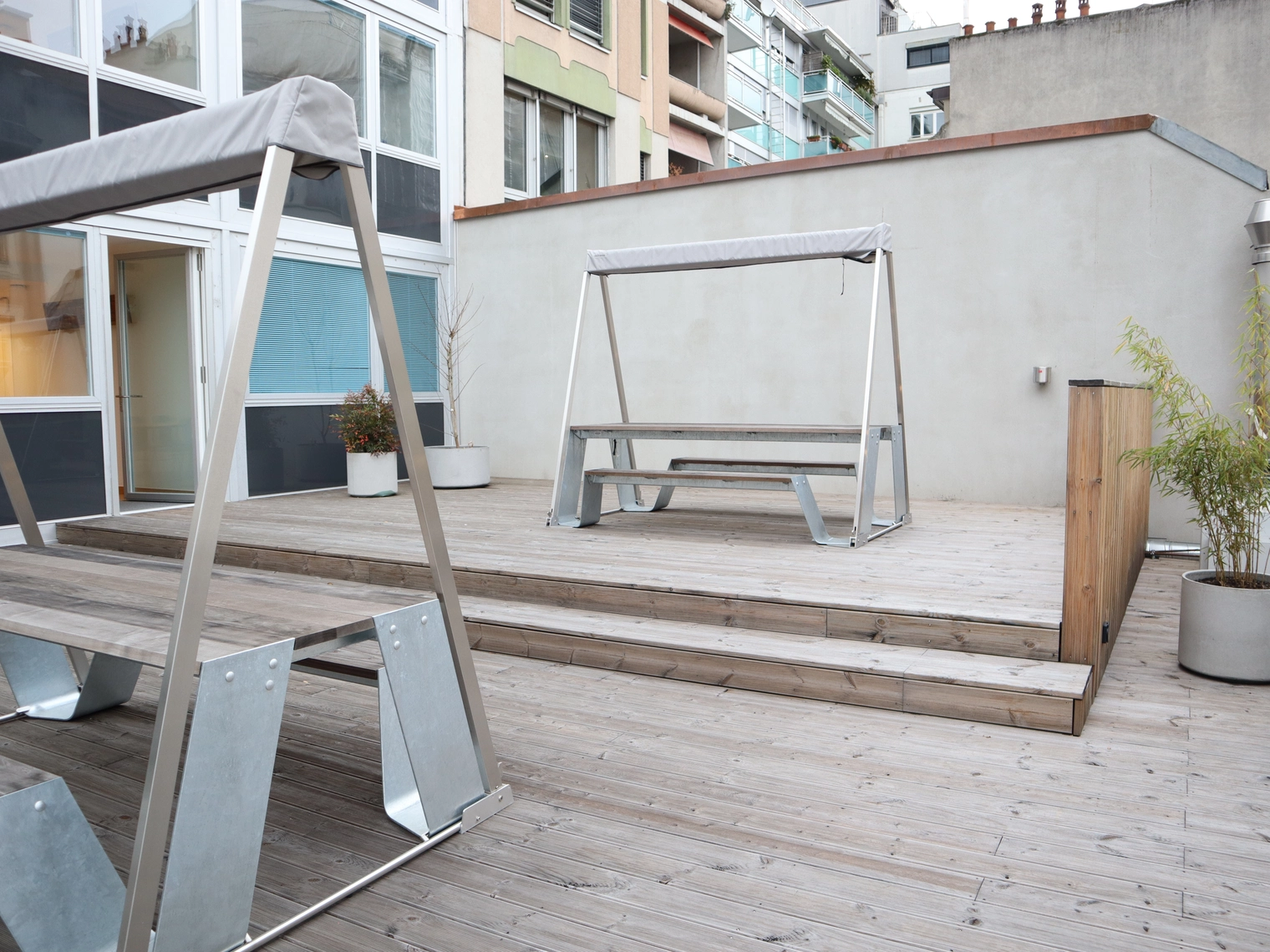 La terrasse du deuxième étage, avec des tables et des bancs