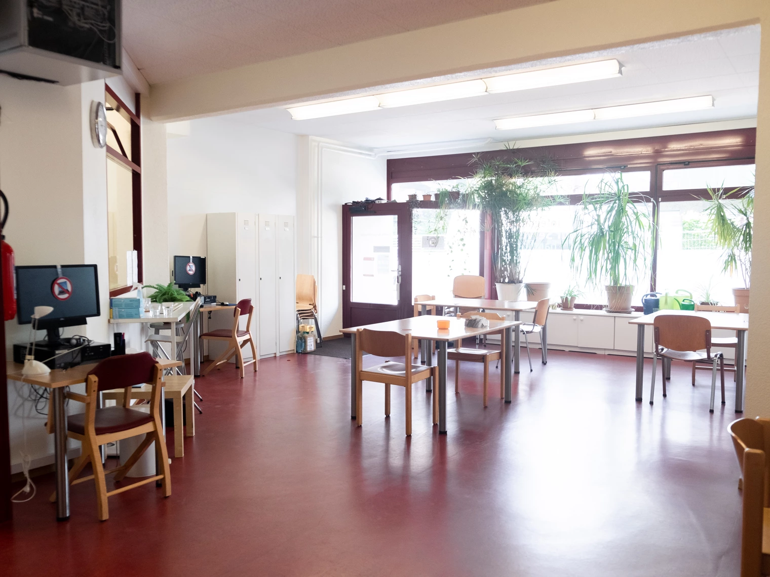 Pièce principale du centre de jour avec des tables et des fenêtres en arrière plan