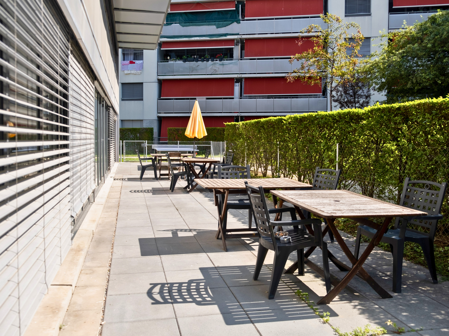 La terrasse de la résidence avec des tables et des chaises d'extérieur