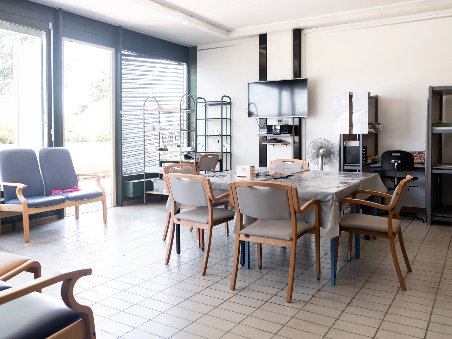 Une salle d'activités spacieuse et lumineuse avec une table et des chaises pour le déroulement des activités 
