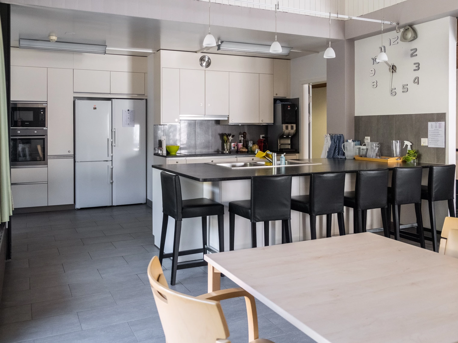 Une cuisine équipée avec un îlot central et des chaises hautes