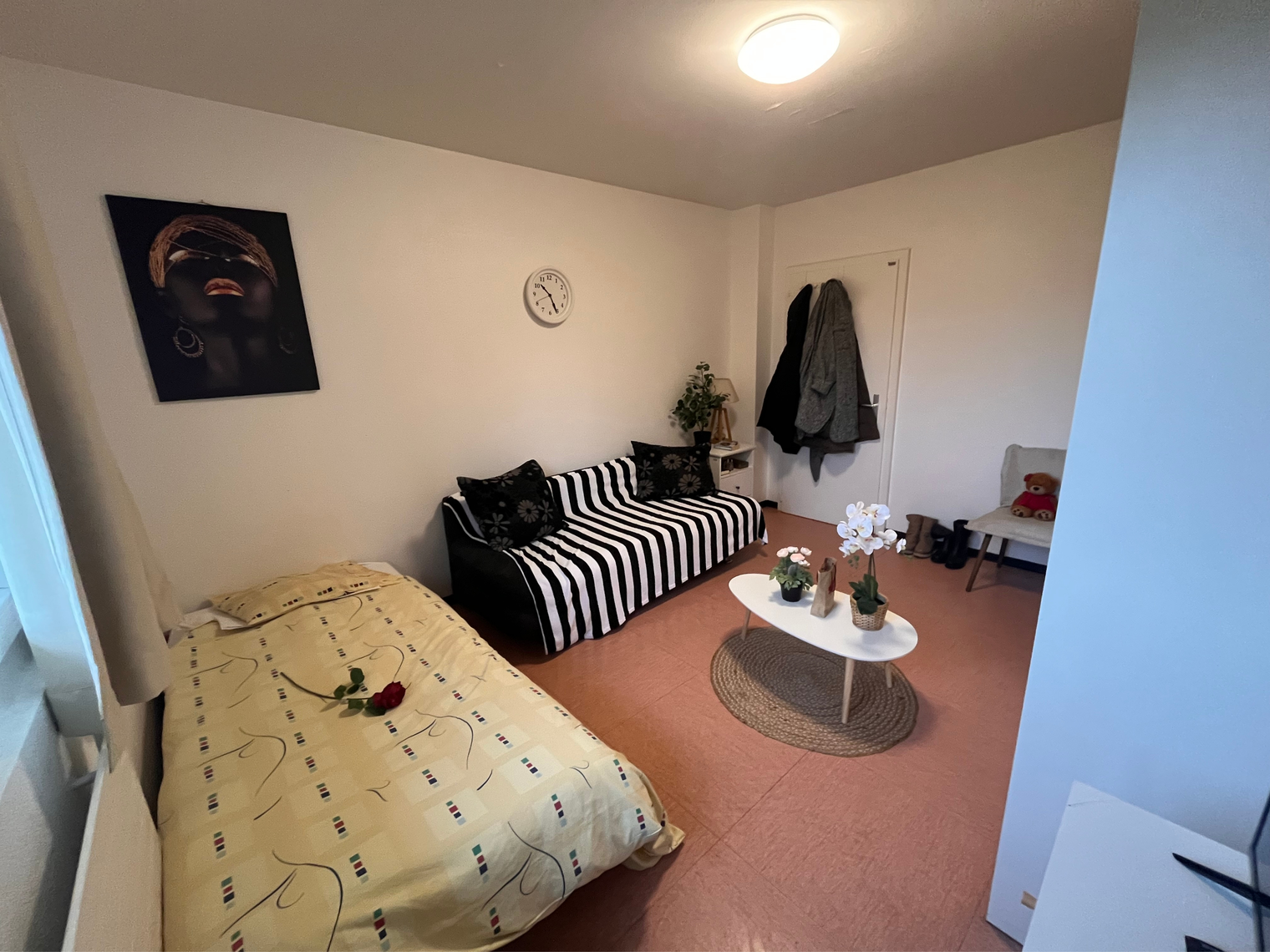 Une chambre avec un lit, un canapé, une table basse et un tableau accroché au mur