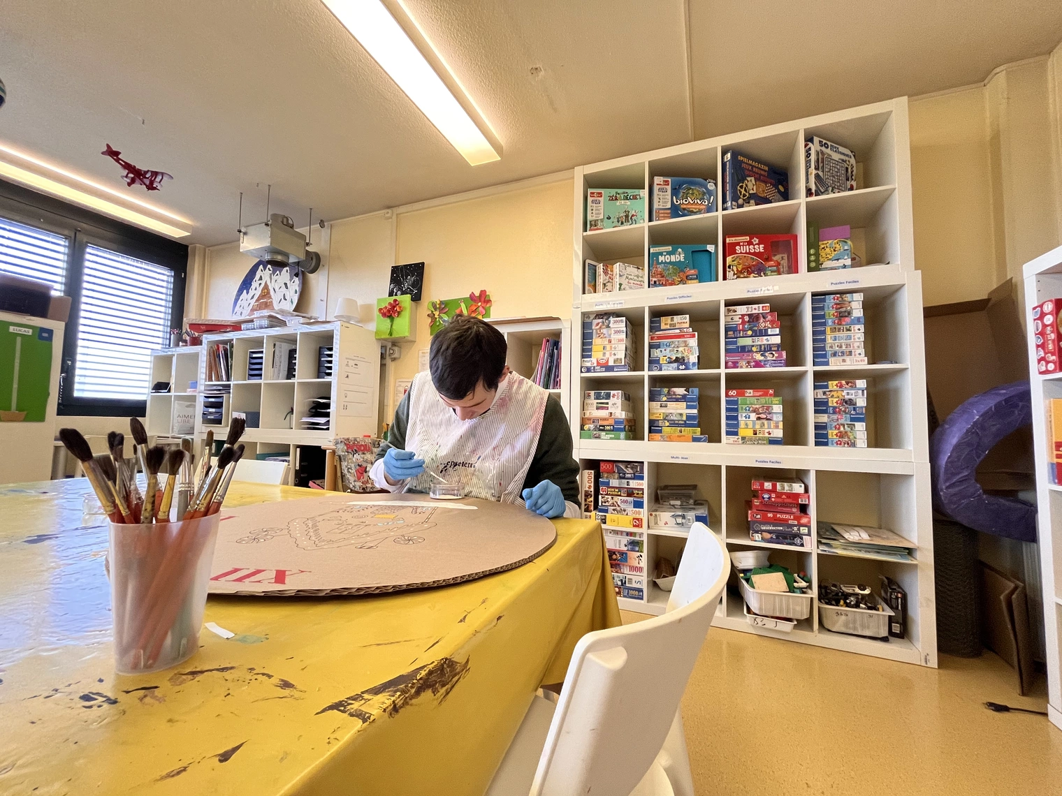 Une salle d'activité avec une personne assise à une table faisant de la peinture