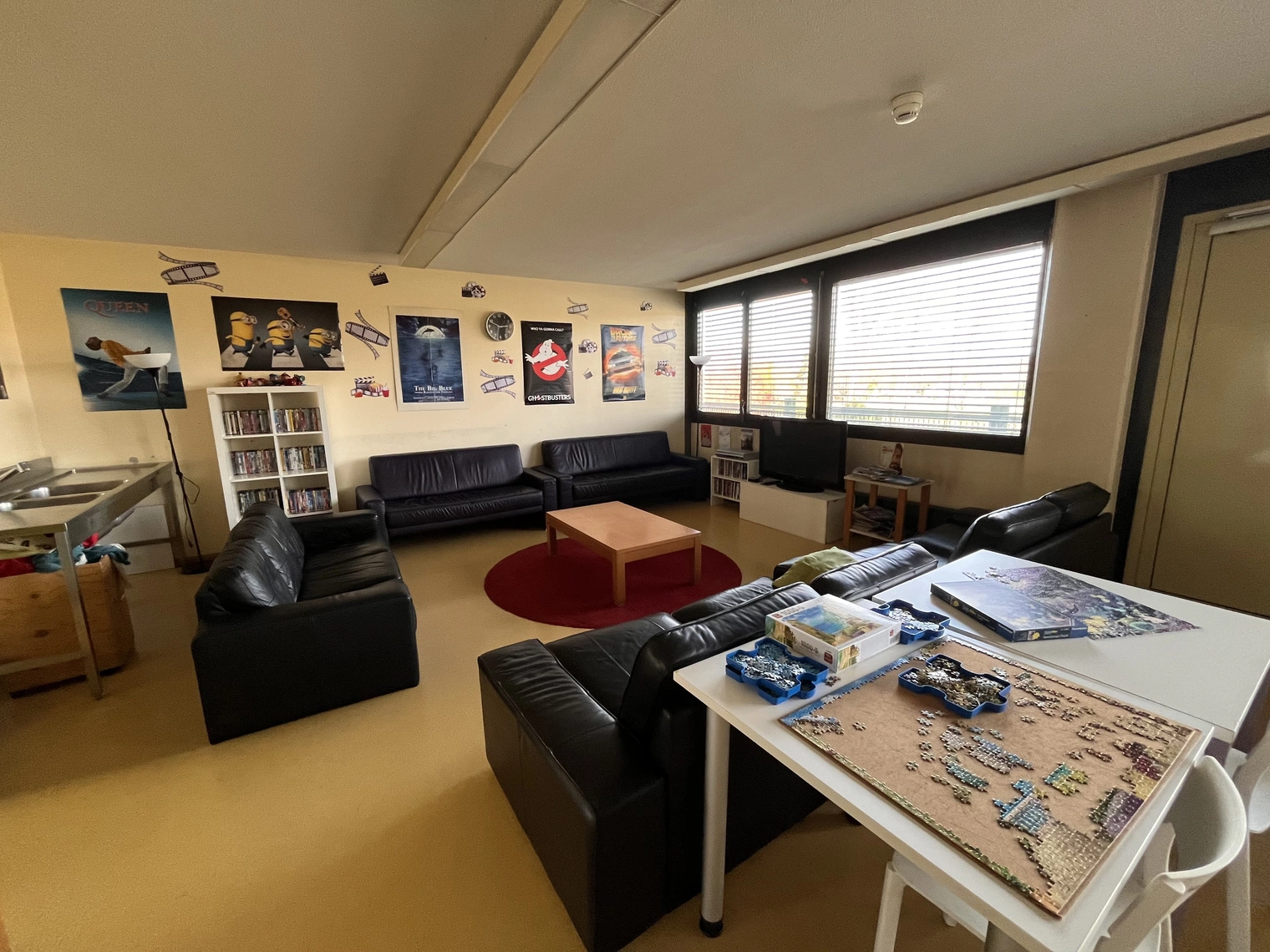 Une salle avec plusieurs canapés, une table basse et un puzzle sur une table 