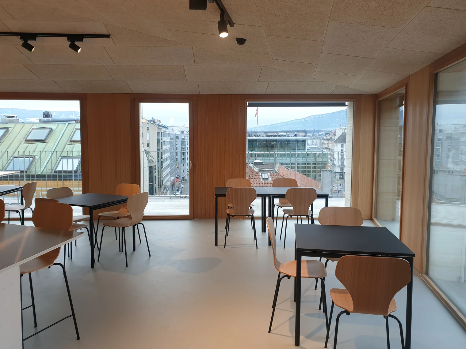 L'attique entièrement vitré, très lumineux, avec des tables et des chaises 