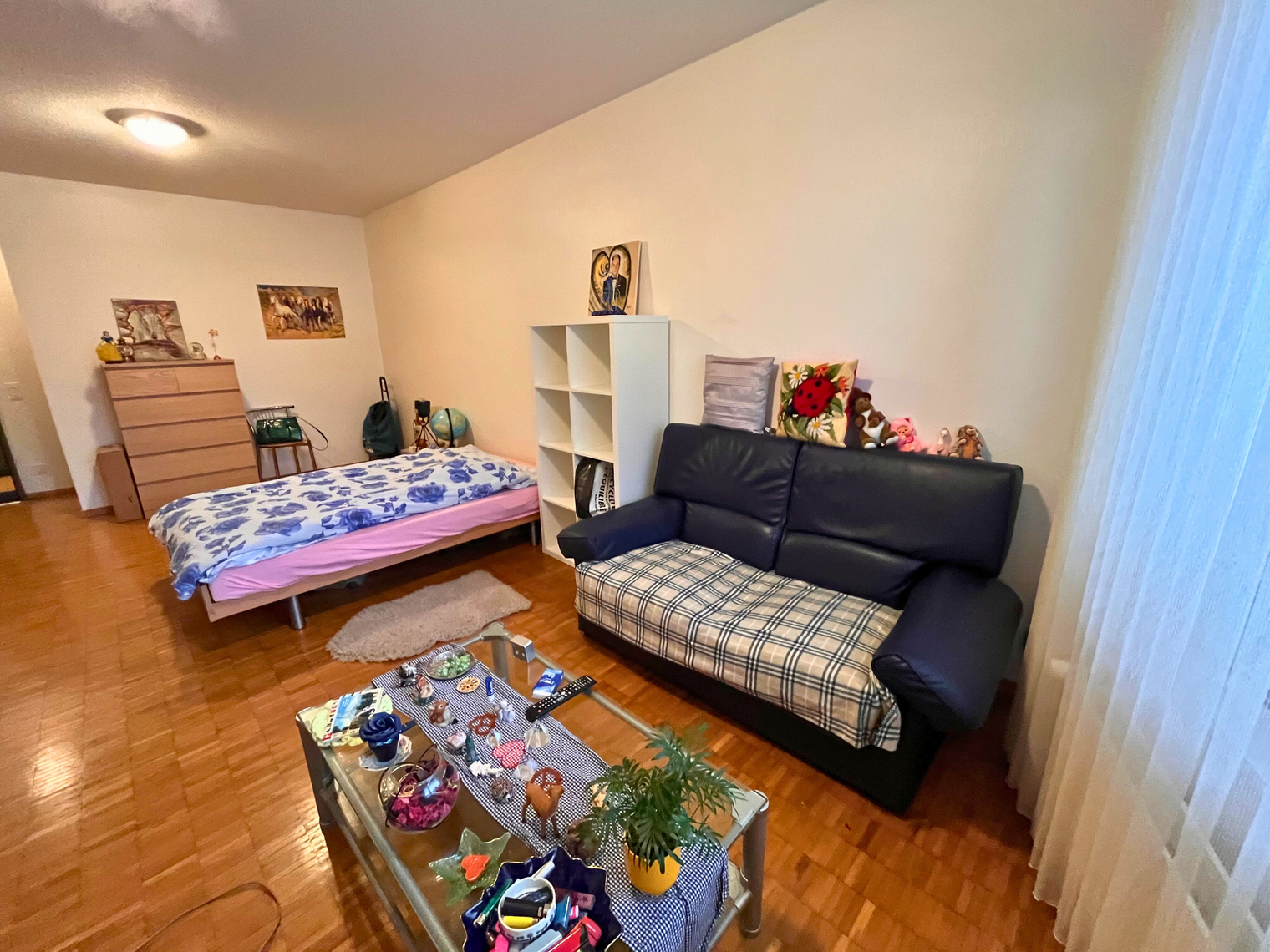 Un chambre avec un lit, une commode, une table basse et un canapé 
